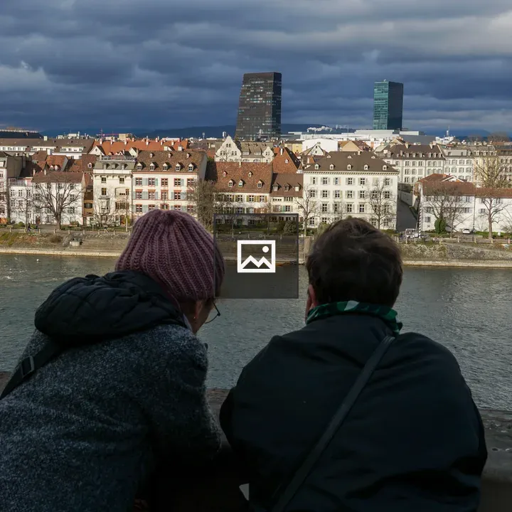 Two people on stone railing by Rhine