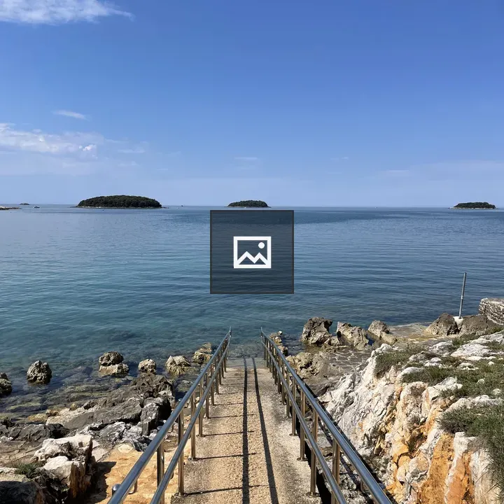 Metal railing pathway to sea