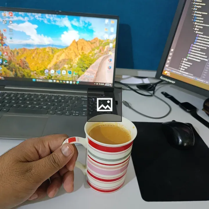 Hand holding striped mug of tea