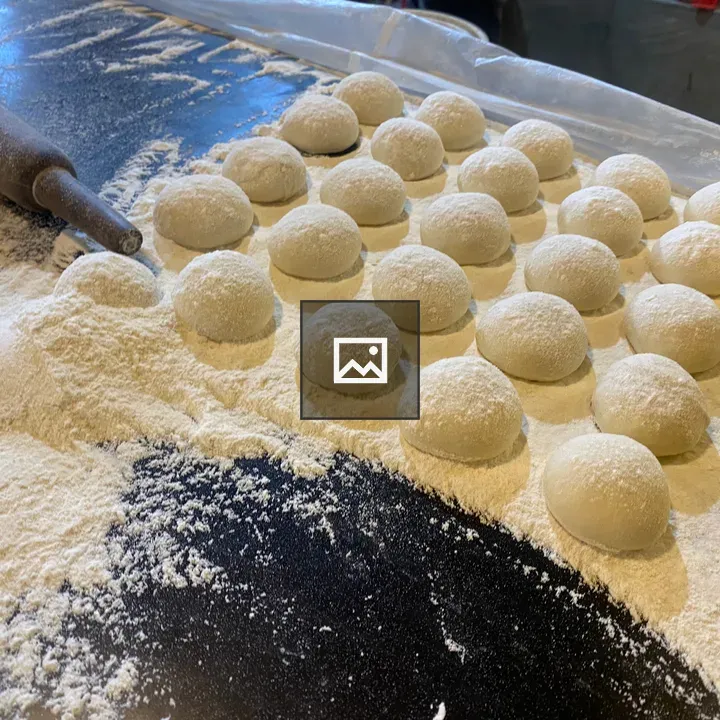 Round dough balls on flour surface