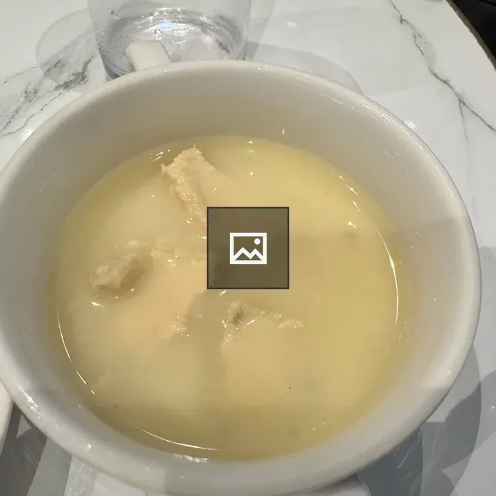 Creamy chicken soup in white bowl