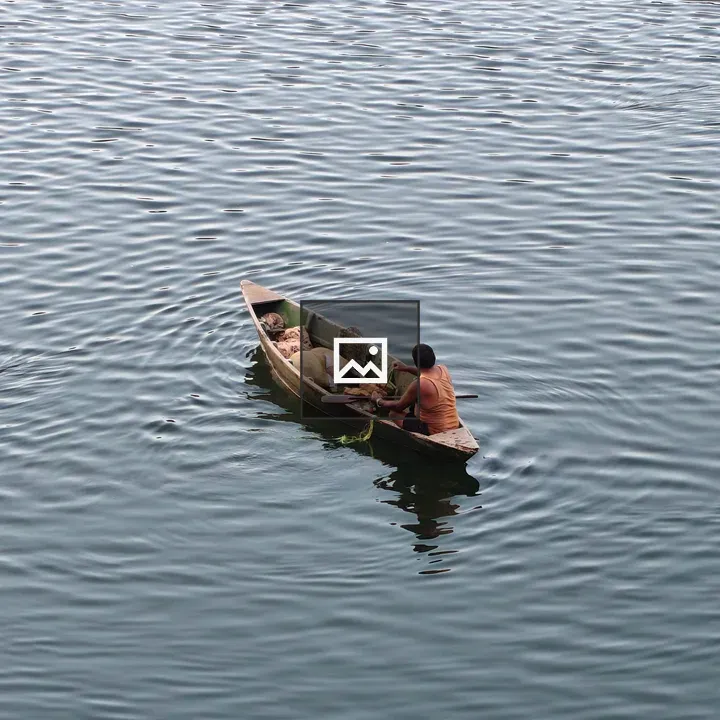 Small wooden boat with lone paddler