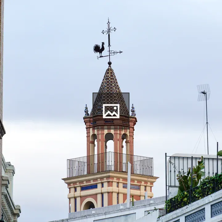 Tall ornate tower with rooster weather vane
