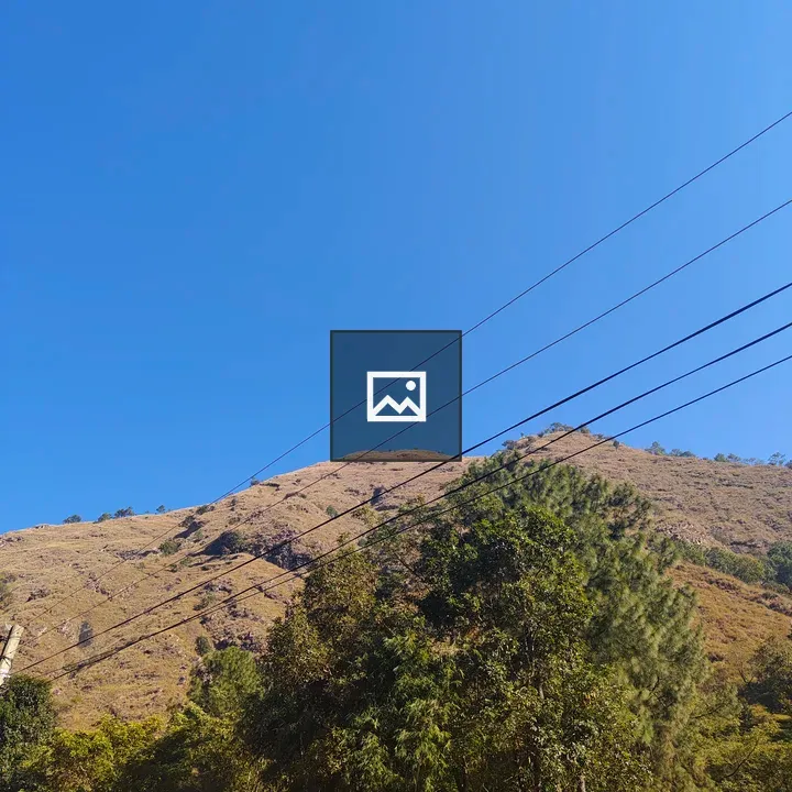 Clear blue sky over mountain with dry grass