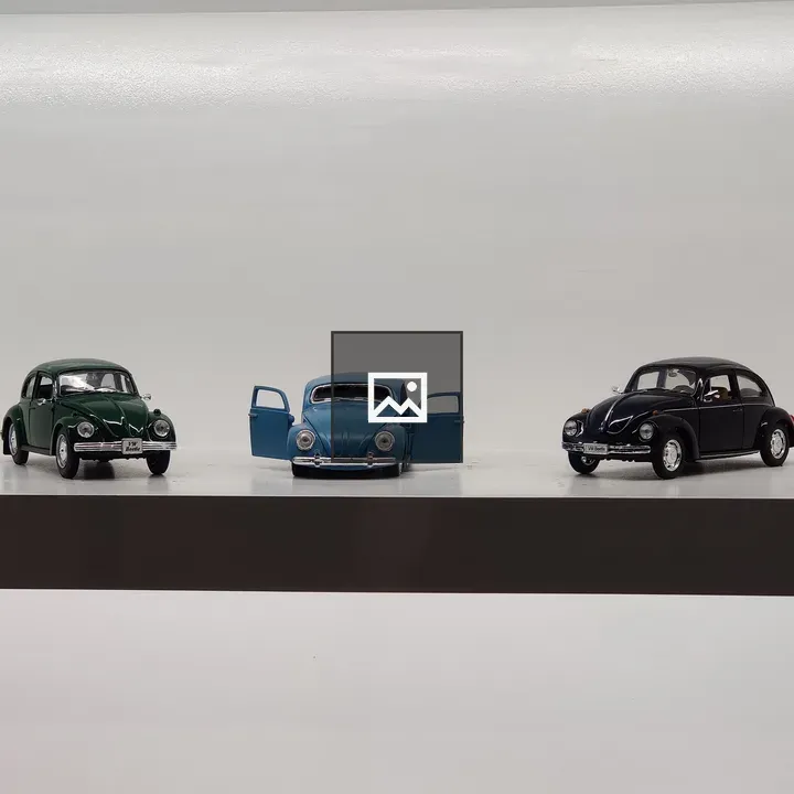 Three Volkswagen Beetles on Shelf