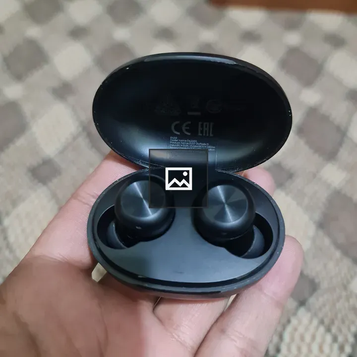 Black earbuds held in hand