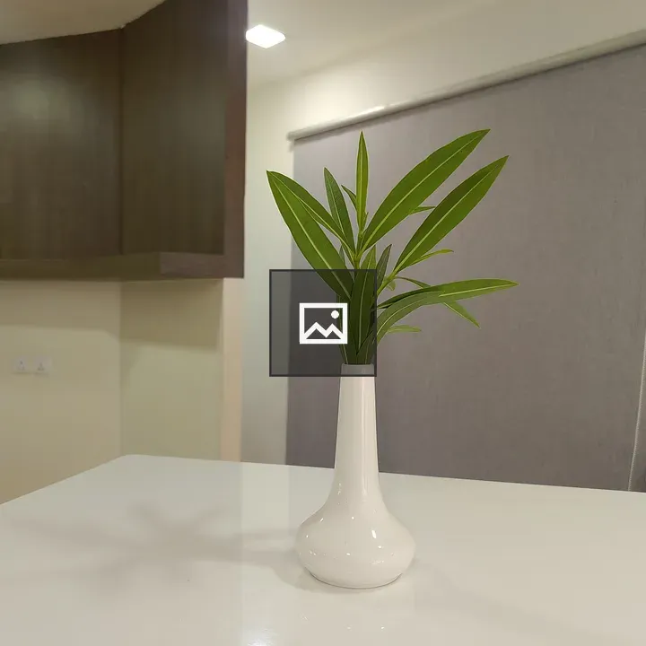 White ceramic vase with green leaves