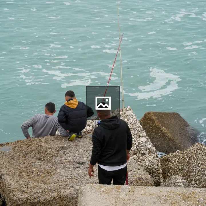 Three People by the Sea on Concrete Blocks
