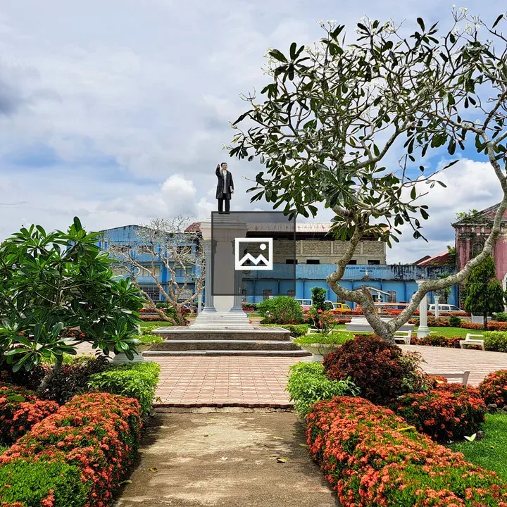 Bust of José Rizal with pink church backdrop