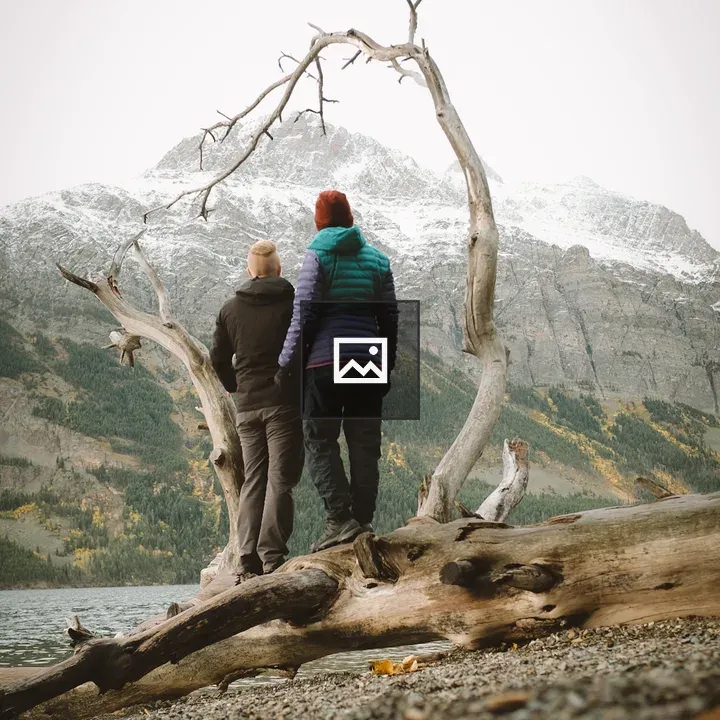 Two people among snowy mountain branches