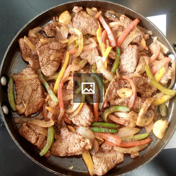 Sliced beef with vegetables in pan