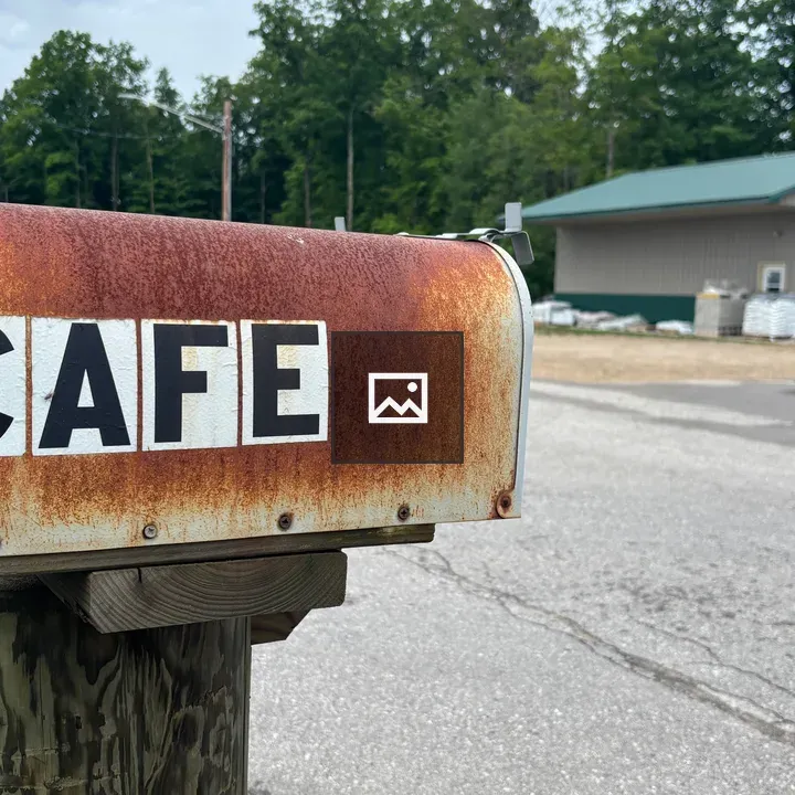 Rusty mailbox with cafe sign