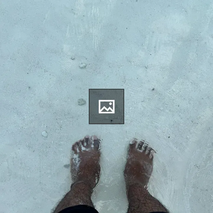 Person wading in clear sea water