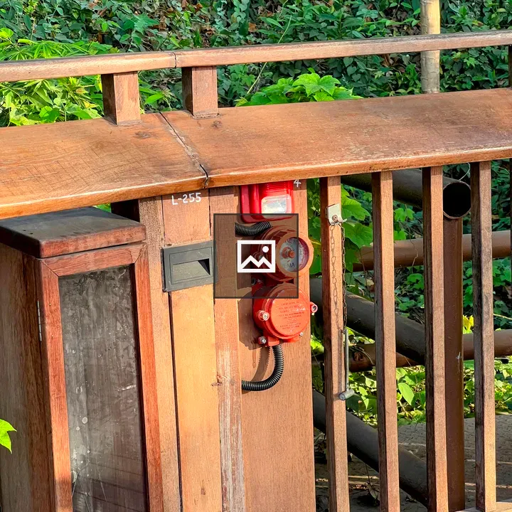Red emergency call point on railing