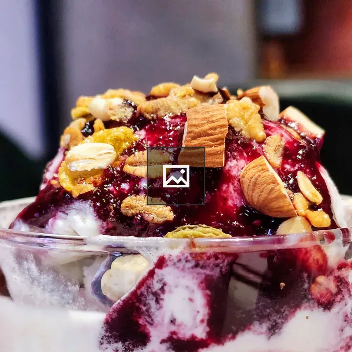 A bowl of ice cream with blueberries