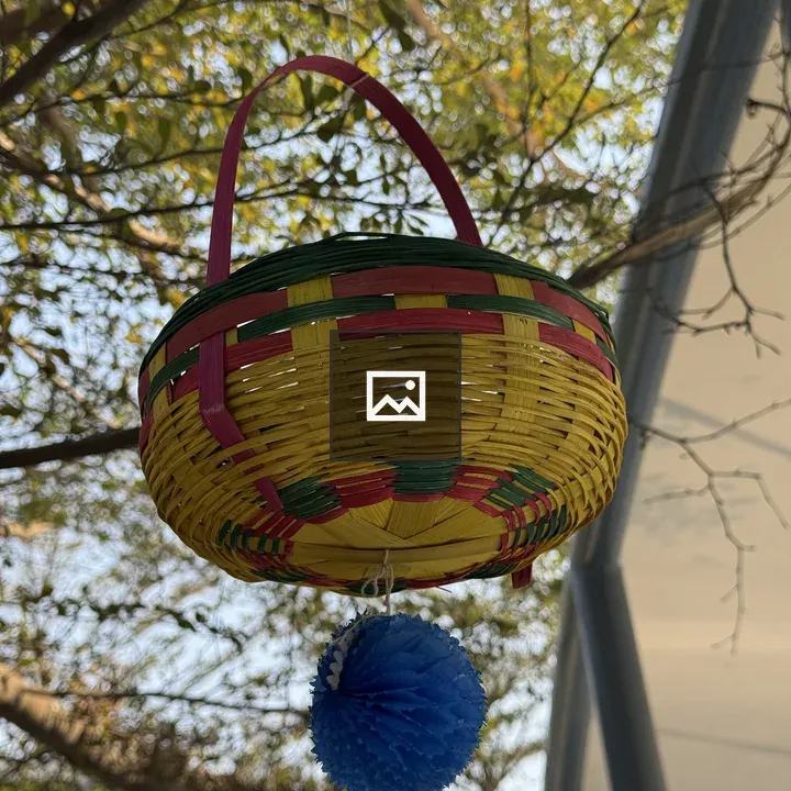 Colorful woven basket on branch