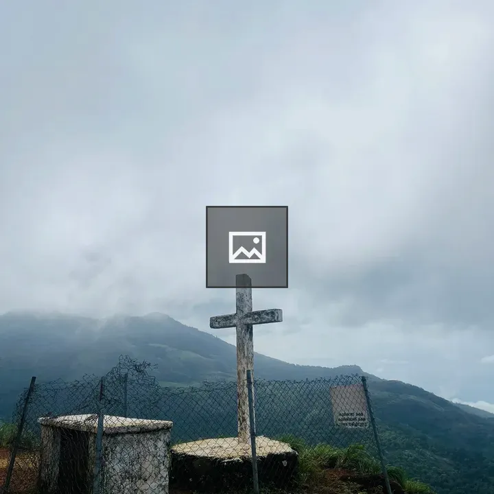 Cross on hilltop with fence
