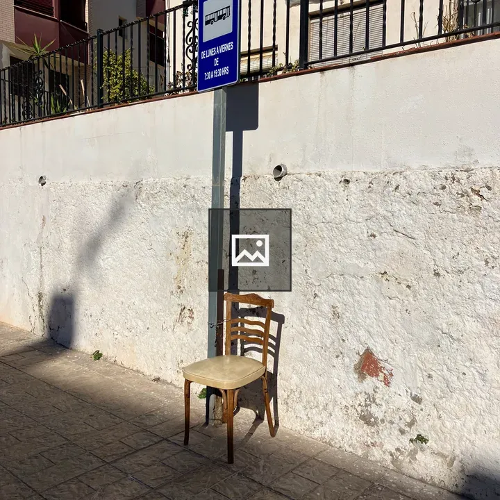 Worn wooden chair by bus stop