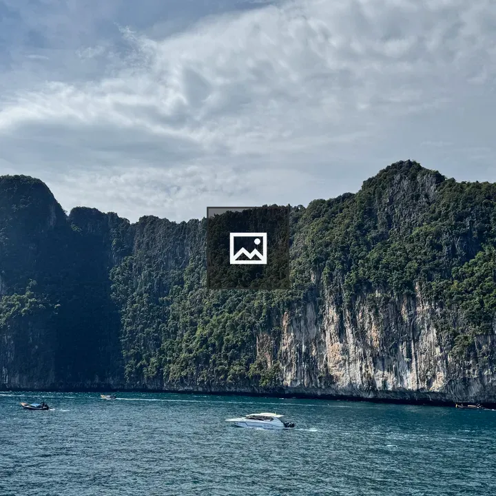Limestone Cliff and Boats on Blue Sea