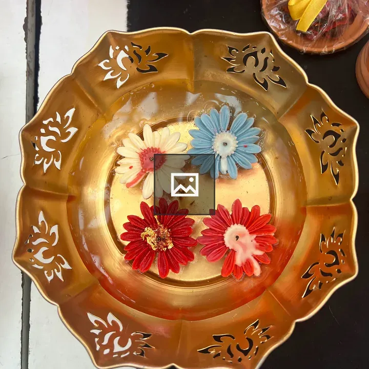 Four flower-shaped candles in bowl