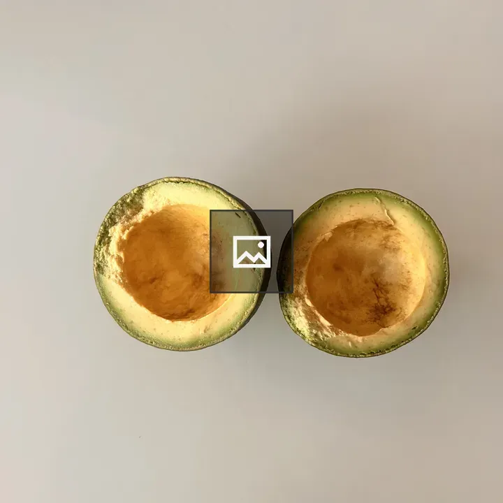 Avocado halves on gray surface