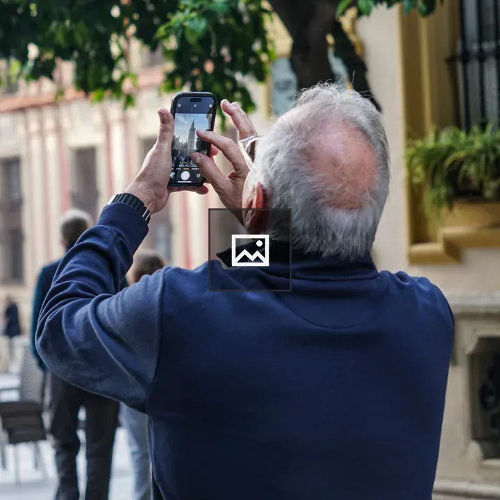 Man photographing Giralda from behind