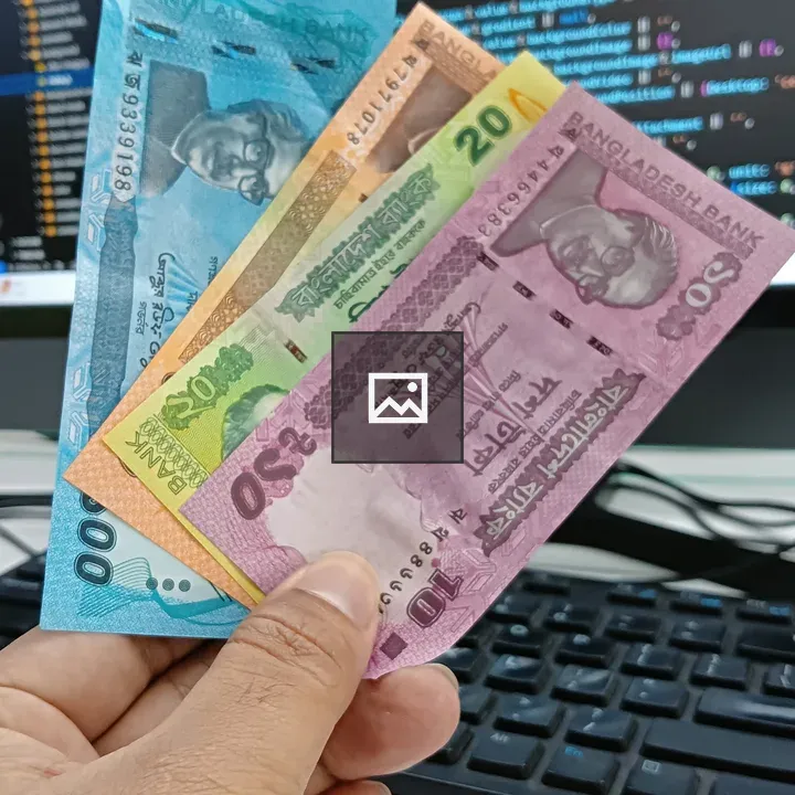 Hand holding three banknotes