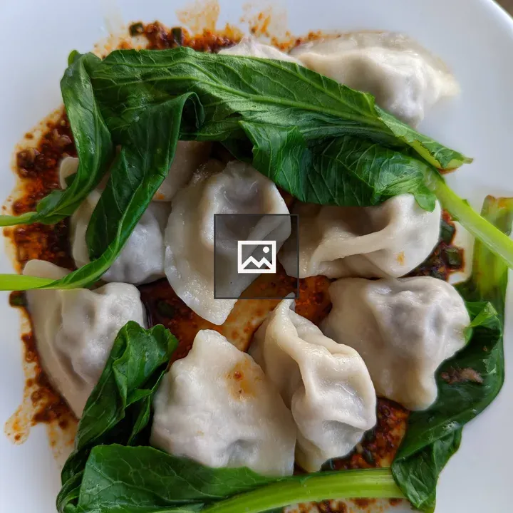 Plate of dumplings on spicy sauce