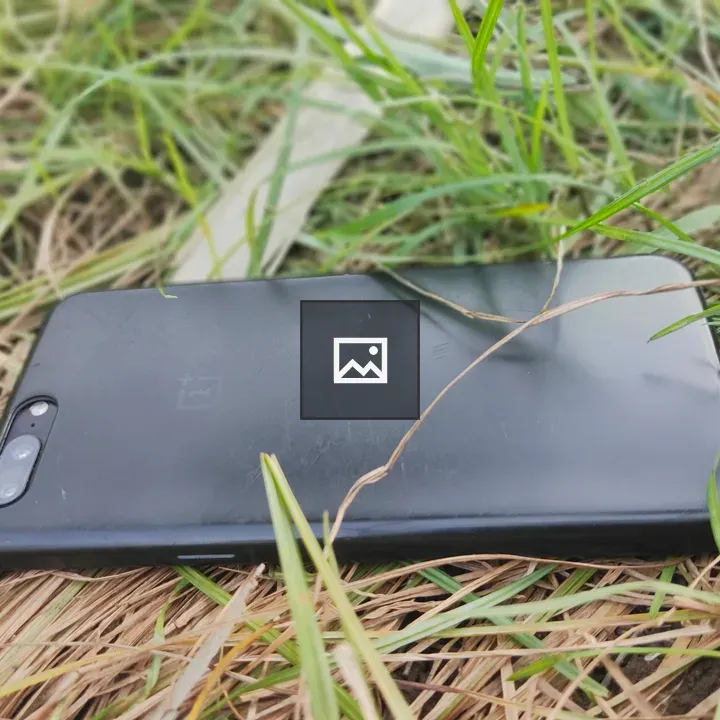 Cell phone facedown on grass