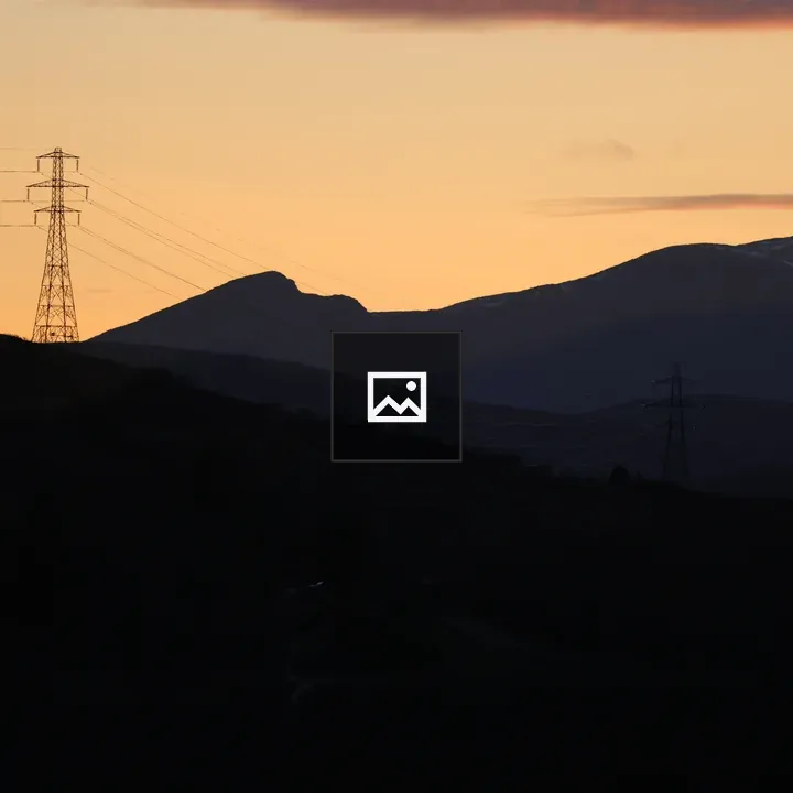 Electricity pylon silhouette on hill