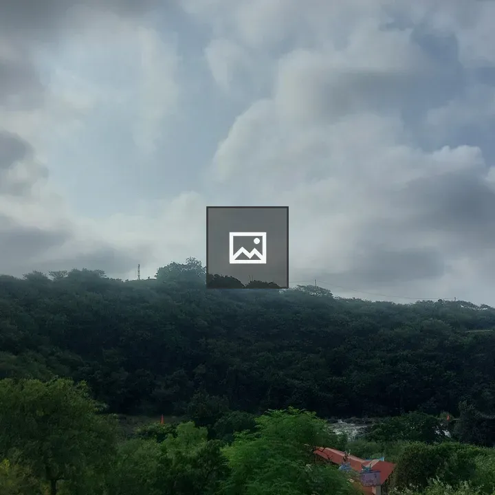 Green hills with red-roofed building