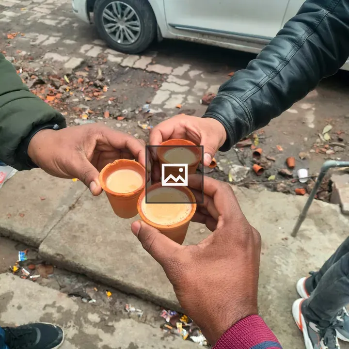 Two hands with chai cups