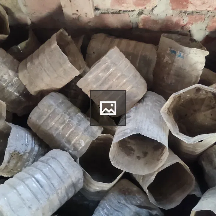Stacked plastic bottles against brick wall