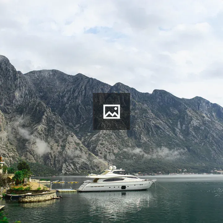 White yacht anchored by stone dock