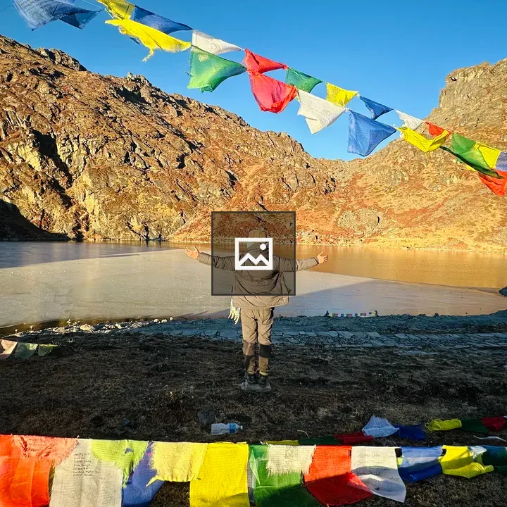 Person by Frozen Lake with Prayer Flags