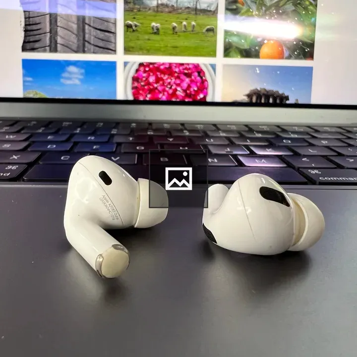 Earbuds and laptop in tech setup