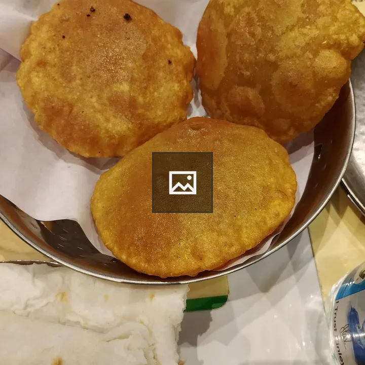 Three puris in a metal bowl