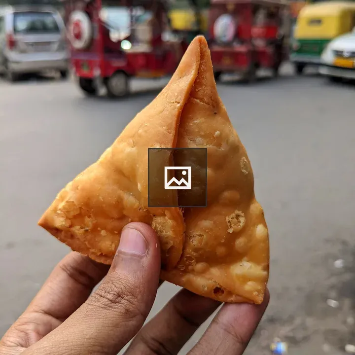 Samosa in Hand with Traffic Blur