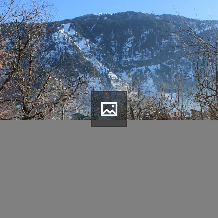 Snowy hillside with house and mountain