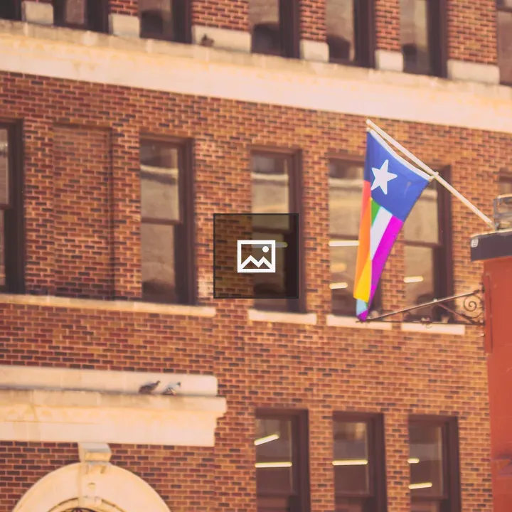 Flag with Rainbow Stripes on Brick Building