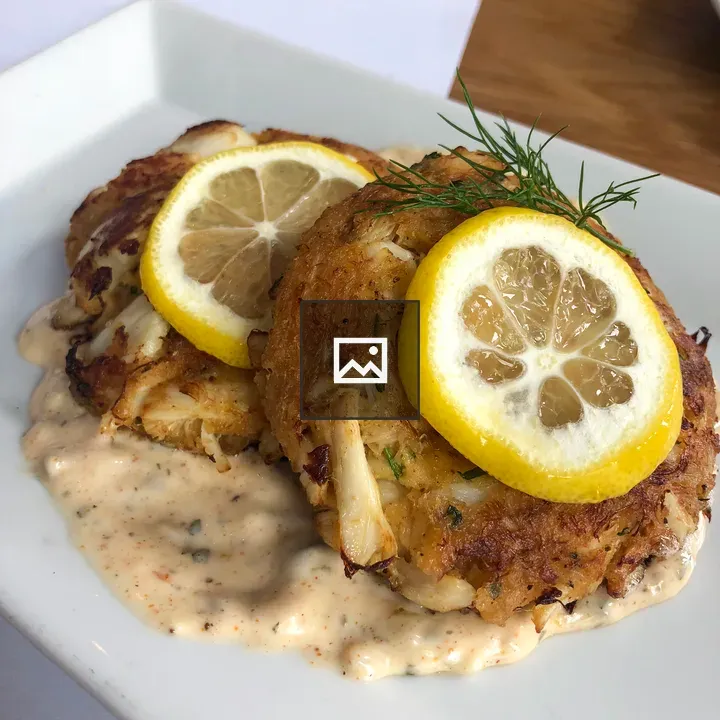Two crab cakes with lemon slices