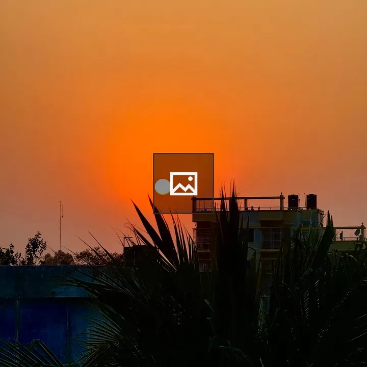 Sunset sky with silhouetted palm and building