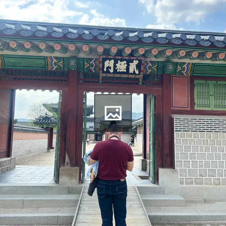 Person near wooden gate with decorations