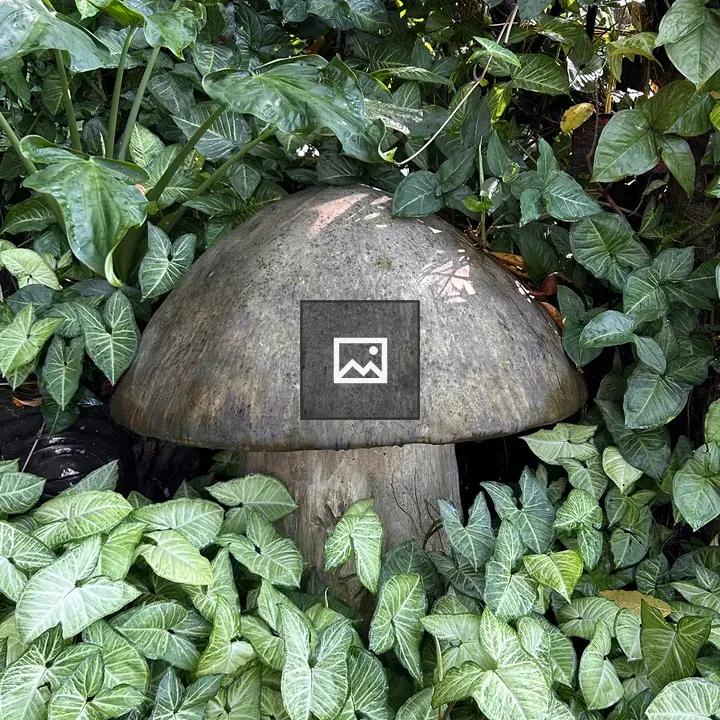 Round mushroom sculpture with foliage