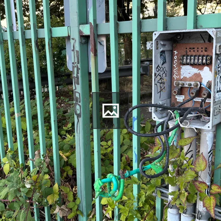 Broken electrical box on fence
