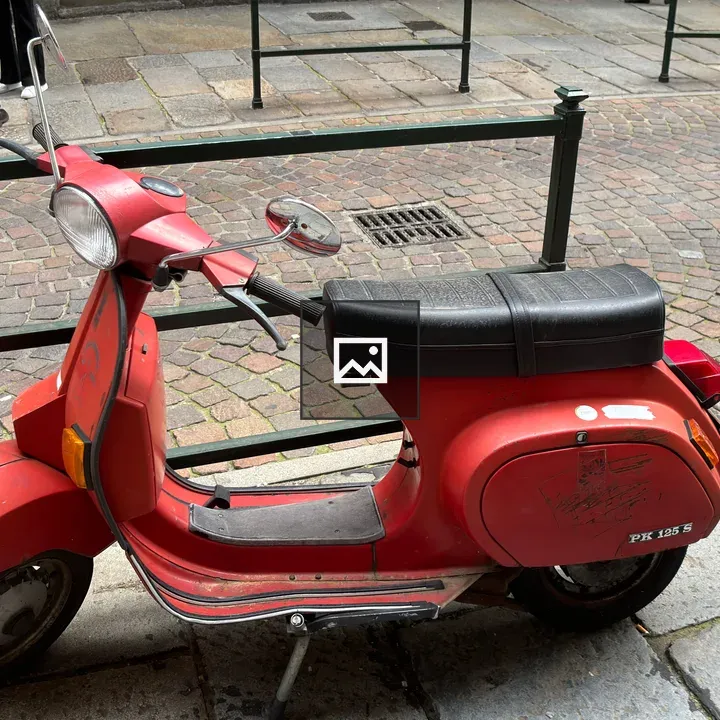 Old red scooter along the street