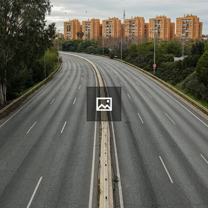 A wide highway with trees and buildings