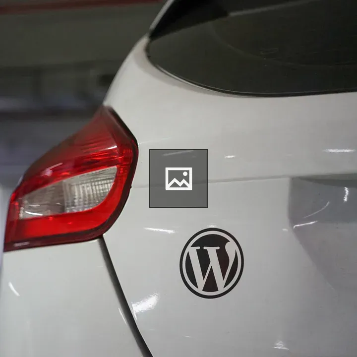 Back view of white car with WordPress sticker