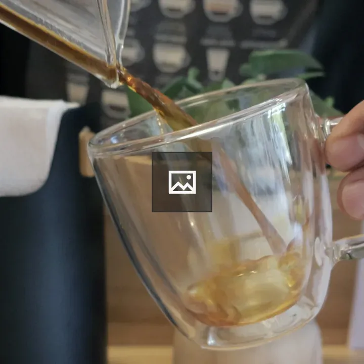 Pouring coffee into a glass cup