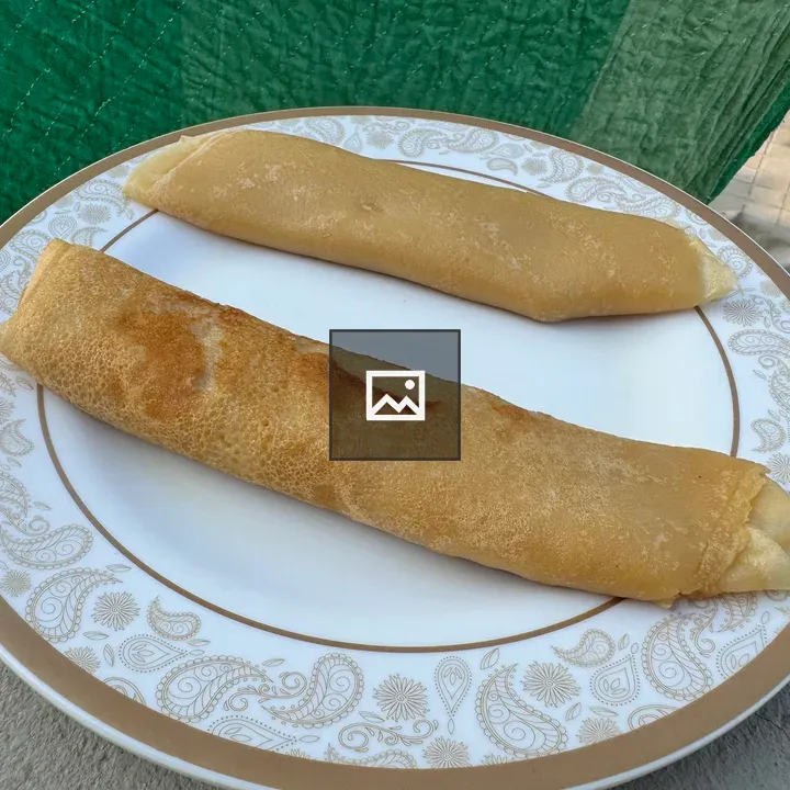 Two crispy dosa rolls on plate